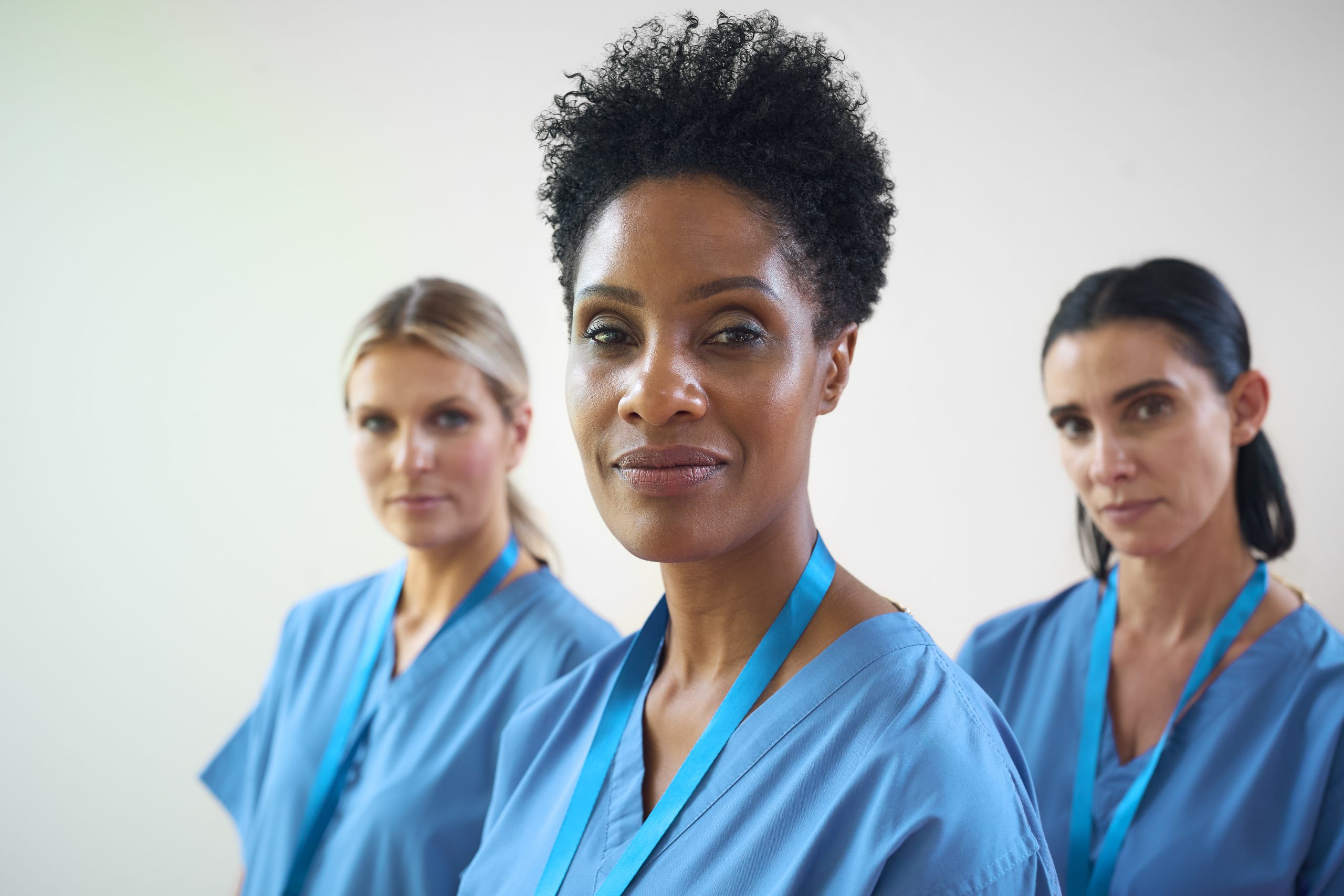 Portrait Of Mature Female Multi Cultural Medical Team Wearing Scrubs In Hospital
